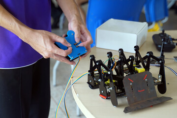 Asian high school students practice moving robots on the playing field To perform missions according to the rules of the robot competition. Soft and selective focus.