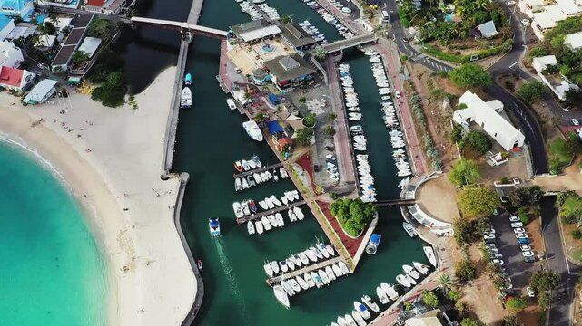 Aerial view of the beautiful harbour and marina with boats near Plage des Roches Noires and the church Paroisse Notre-Dame-de-la-Paix, Saint-Gilles-Les-Bains, Reunion.