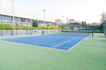 Empty tennis court with blue and green surface in a sports complex