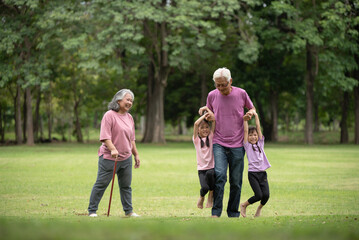 Fototapeta premium Happy Asian family children having fun and playing with her grandparents in the park
