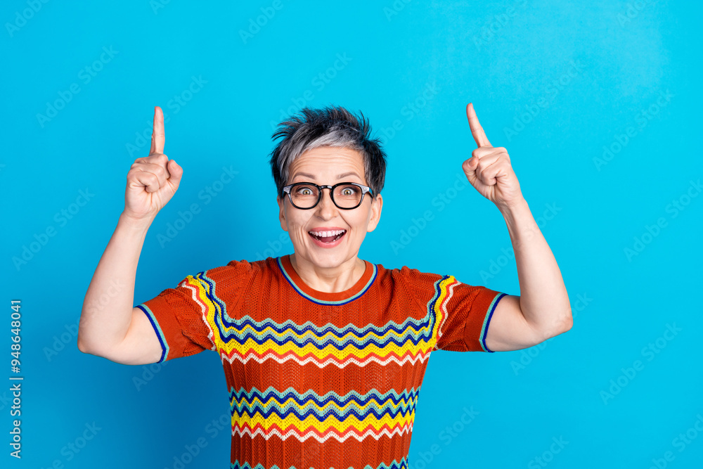 Sticker photo of nice aged lady direct fingers up empty space wear t-shirt isolated on blue color background