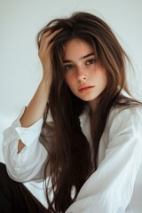 Naklejka premium Photo of a beautiful young woman with long hair, wearing a white...