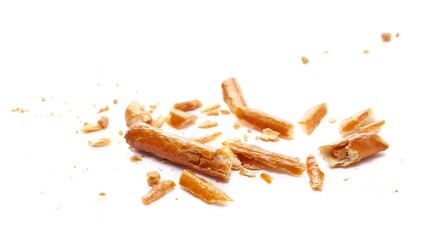 Broken salty cracker pretzel sticks, stuffed with peanuts, crumbs isolated on white
