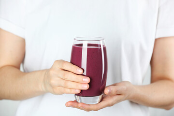 Woman with glass of tasty fresh acai juice, closeup