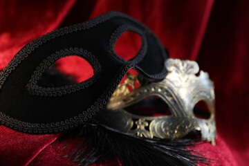 Beautiful carnival masks on red silk fabric, closeup