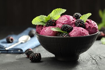 Delicious blackberry sorbet, fresh berries and mint in bowl on gray textured table