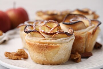 Freshly baked apple roses and walnuts on table, closeup. Puff pastry