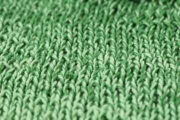 Texture of green knitted fabric as background, closeup