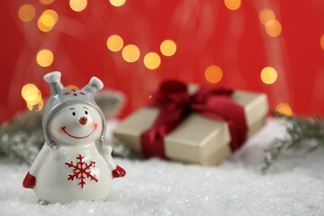 Cute decorative snowman on artificial snow, closeup. Space for text