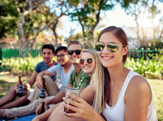 Student, portrait and drinks with happy friends, picnic and park with smile in summer on campus. University, break and group with bonding and alcohol on lawn of college with Gen Z beer social