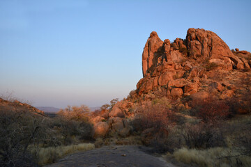 Evening dirt road near a cliff in the desert at sunset. Hiking and tourism. Hot and dry climate