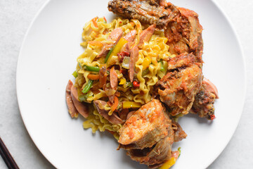Overhead view of Singaporean noodles on a white plate, top view of Singaporean fusion noodles