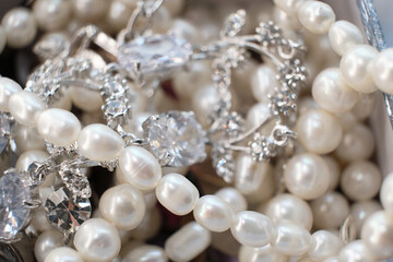 An assortment of pearls and silver jewelry with sparkling diamonds, emphasizing their intricate...