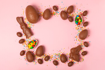 Easter chocolate egg on textured background. Easter celebration concept. Easter chocolate rabbit. Chocolate sweet eggs. Candies on textured wooden table. Space for text.Copy space. Gift. Banner.