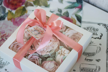 Naklejka premium A box of homemade marshmallows. Tied with a ribbon. The tag has the inscription in Russian From the bottom of my heart. Flowers made of marshmallow.