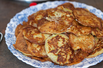 Prepared zucchini pancakes on a plate. Coocking at home concept.