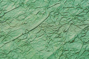 Crumpled matte green paper. Wrapping paper.
Abstrack background, wallpaper. Green minimalistic background	