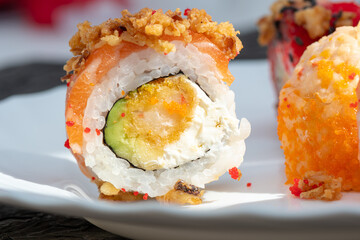 Delicious sushi rolls on a white saucer. Detailed photo of sushi roll 
filling. Eating sushi rolls at home. Close up