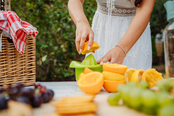 Close up of woman's hands using hand juicer for orange and lemon 