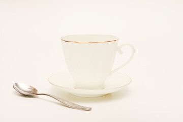 Tea pair on a white background. A cup and saucer with a spoon.