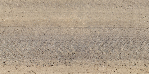 view from above on texture of dry muddy road with tractor tire tracks in countryside