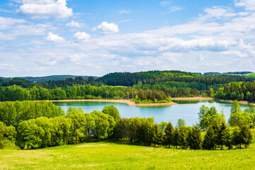 Obraz premium View of Jaczno lake from hill with green meadow and trees, Suwalski Landscape Park, Podlasie, Poland