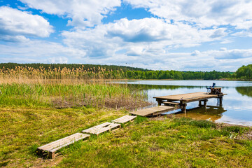 Fishing chair on wooden pier at beautiful lake during sunny summer day, Suwalski Landscape Park, Podlasie, Poland