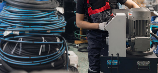 Manufacturing process Worker crimps pressure hydraulic hose with fitting on machine