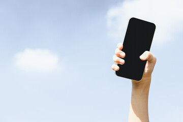 Recyclable smartphone held in hand up on sky background. Hand holding electronic waste for recycle reduce and reuse concept to promote clean environment with recycling management. Gyre