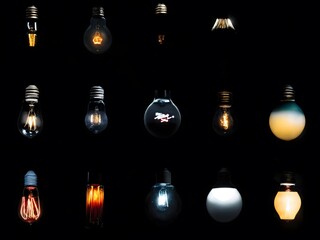 Various light bulbs illuminated against a dark background showcasing diverse designs and shapes for creative inspiration