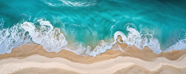 Obraz premium Aerial view of clear turquoise ocean waves gently crashing onto a sandy beach under bright sunlight