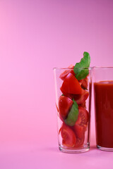 tomato juice in a glass glass and fresh tomatoes in a glass with basil