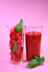 tomato juice in a glass glass and fresh tomatoes in a glass with basil