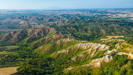 An aerial view of Le Balze di Volterra and the San Giusto Volterra in Tuscany, Italy, captured by a drone. Le Balze di Volterra is a dramatic and unique landscape of steep cliffs