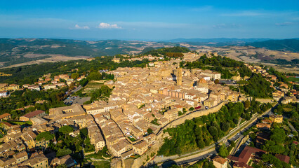 An aerial view of Volterra, a stunning medieval town in Tuscany, Italy, captured by a drone. Known for its ancient Etruscan origins and well-preserved architecture, Volterra is perched atop a hill