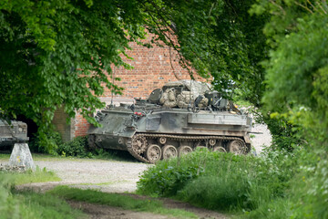 Fototapeta premium Army FV432 dark green transport tank parked by empty buildings
