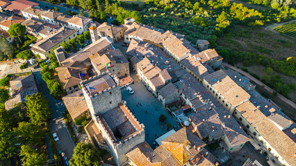 An aerial view of Castellina in Chianti, a picturesque town in Tuscany's renowned Chianti wine region, captured by a drone. Perched on a hill, Castellina in Chianti is surrounded by rolling vineyards 