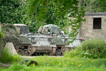 British army Bulldog FV432 dark green transport tank parked by empty buildings