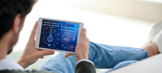 Young man using smart home security system control panel, closeup