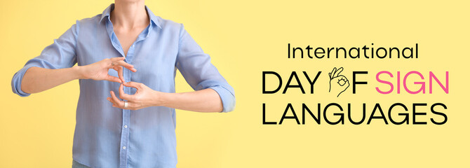 Young deaf mute woman using sign language on color background