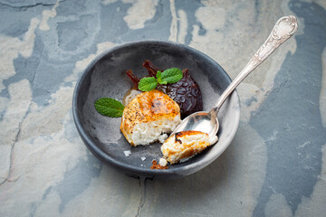 Traditional Greek goat's cheese gratinated with plums and salt served as close-up on a design plate...