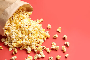 Paper bag with crispy popcorn on red background