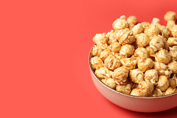 Bowl with crispy popcorn on red background