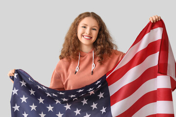 Young woman with USA flag on grey background