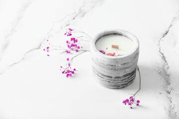 Holder with candle and flowers on white background