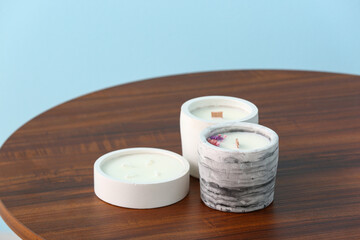 Holders with candles on table near blue wall in room, closeup
