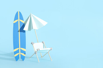 Creative composition with miniature surfboard, deckchair and umbrella on blue background