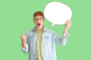 Angry young redhead man with blank speech bubble on green background