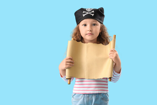 Cute little girl dressed as pirate with treasure map on blue background