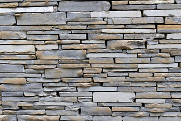 Fototapeta premium Light brown and grey stone wall with empty space in between. Beautiful stone pattern, background. Wallpaper